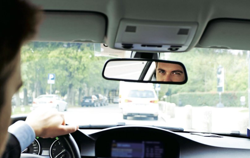 Водитель в зеркале заднего вида