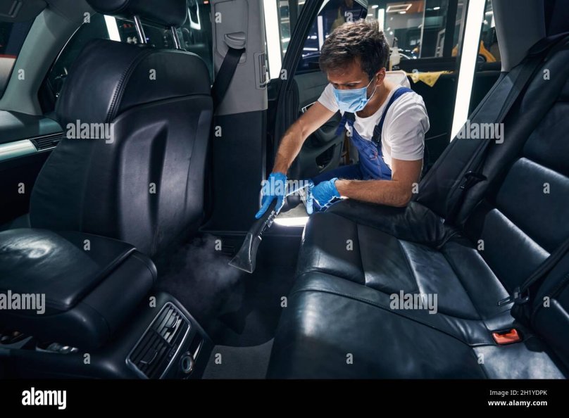 Мужчина пылесосит авто