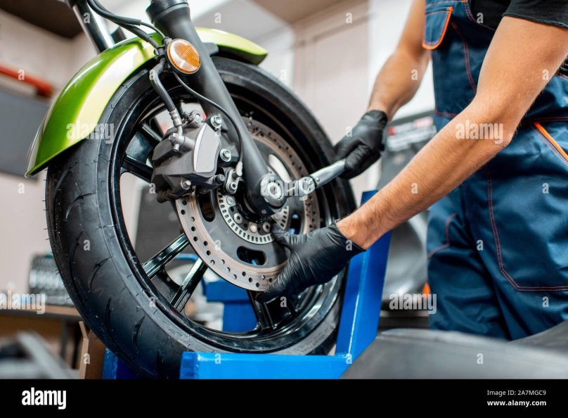 Ремонтирует мотоцикл